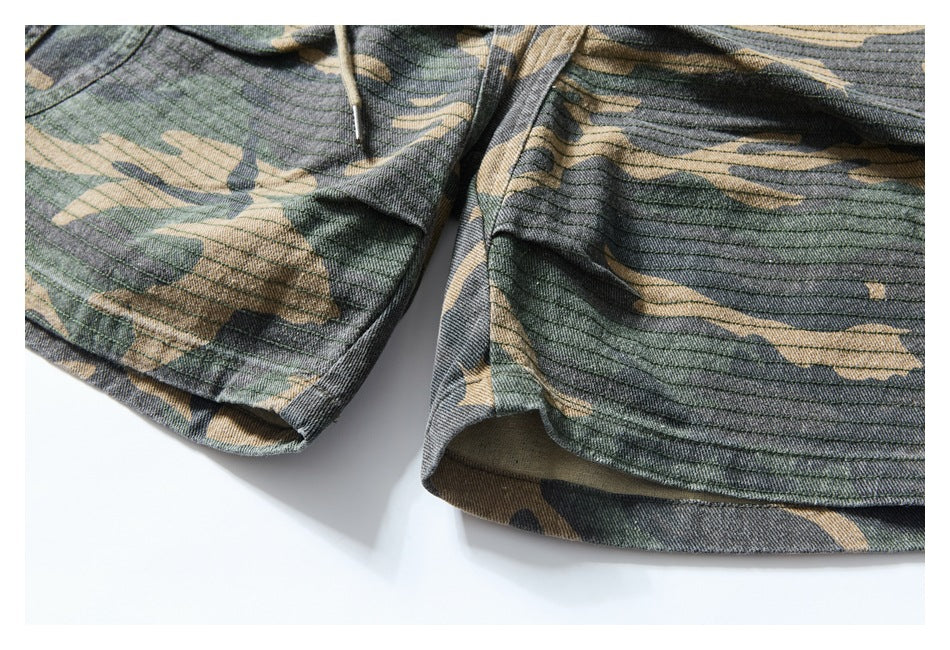 Close-up of camouflage shorts showing the leg hems and stitched fabric.