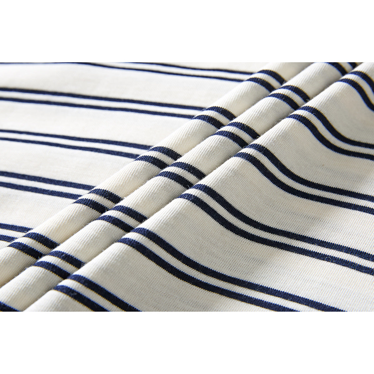 Close-up of ivory knit fabric with narrow navy horizontal stripes and soft folds.