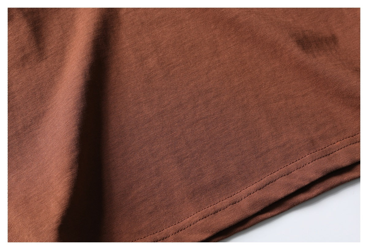 Close-up of a rust-brown T-shirt hem with double-row stitching.