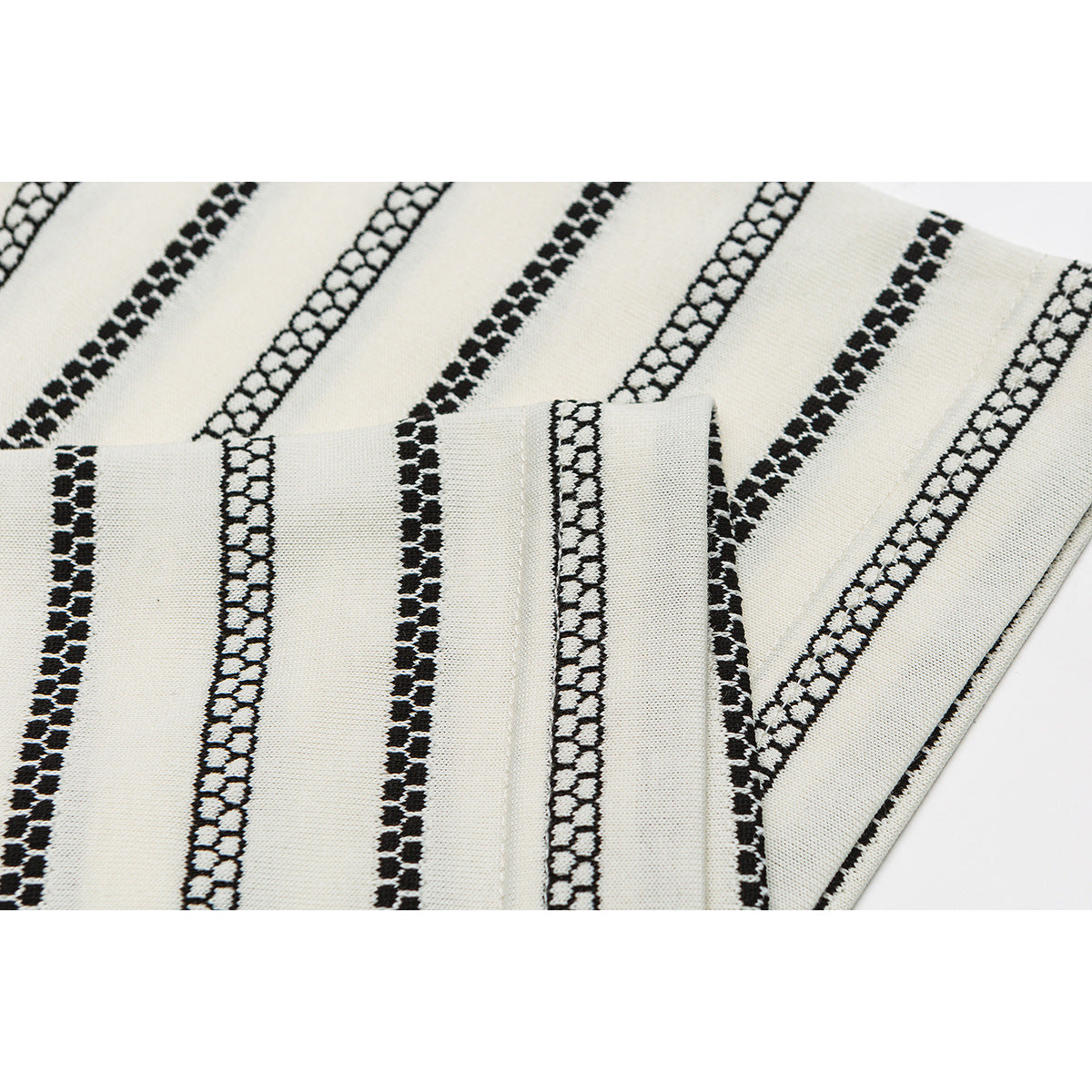 Close-up of ivory striped T-shirt fabric with a folded sleeve or hem showing the stripe pattern.