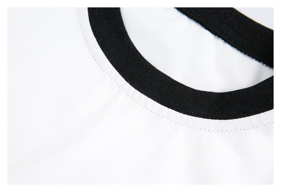 Angled close-up of the white shirt's black ribbed neckline and stitching.