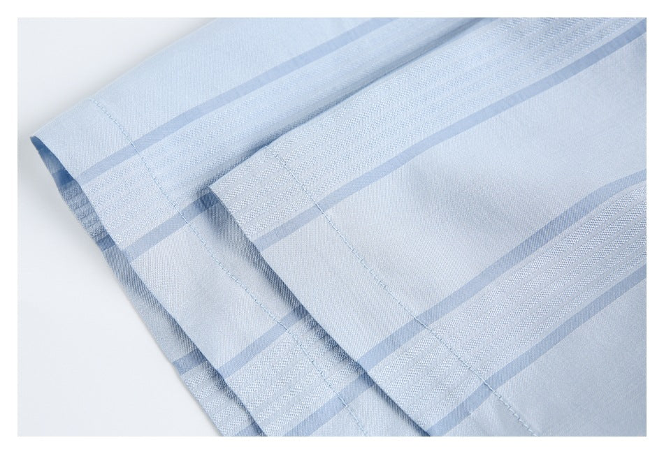 Close-up of light blue striped fabric with a stitched folded edge.