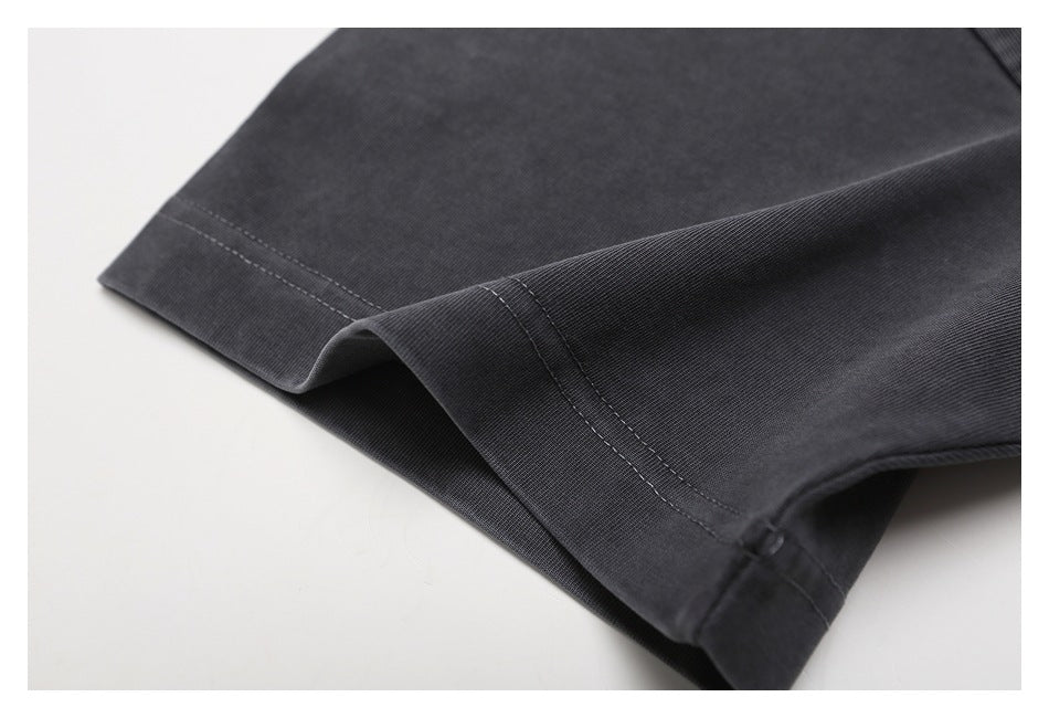 Close-up of the charcoal T-shirt's folded sleeve hem with visible double stitching.