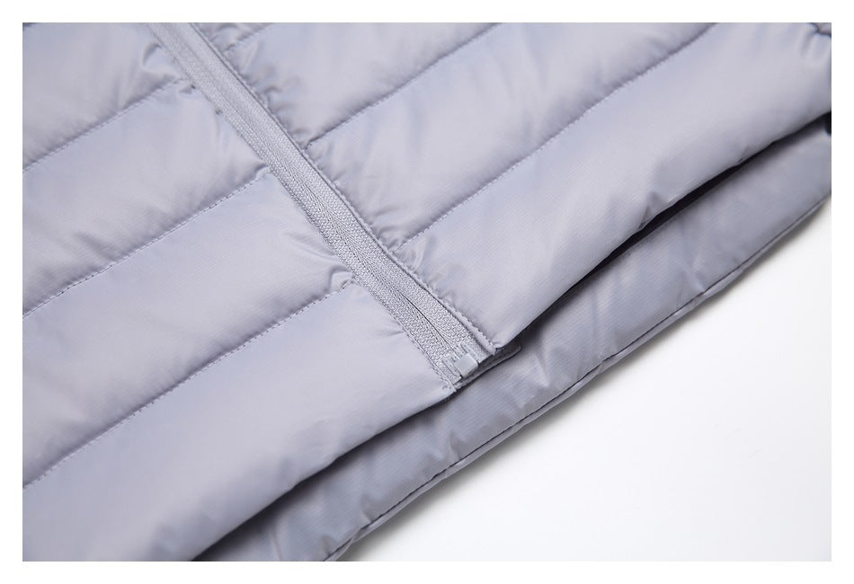 Close-up of the light gray-lavender vest's front zipper, quilted panels and lower hem.