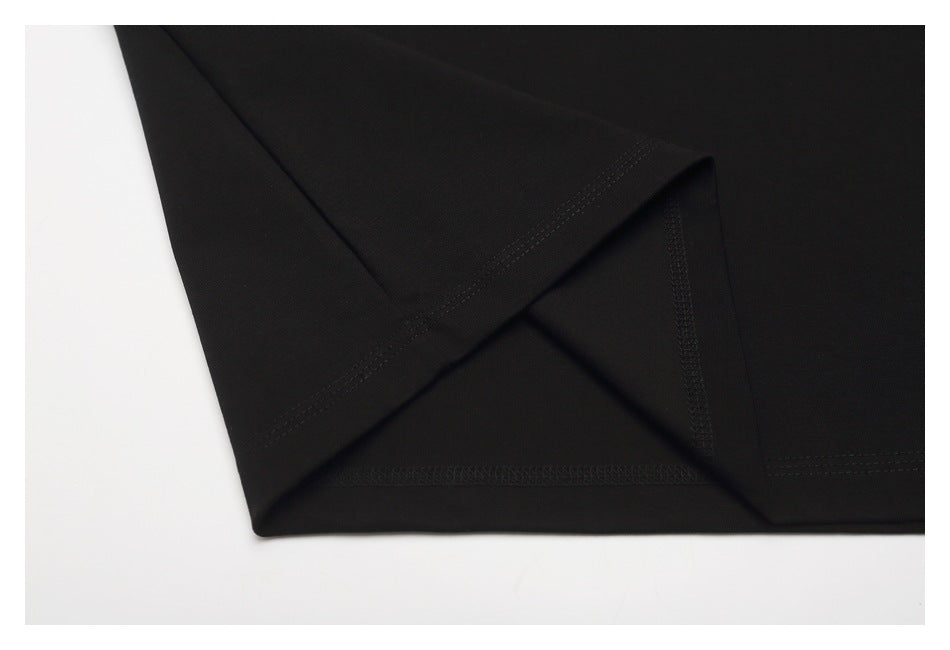 Close-up of a black T-shirt side seam and stitched hem construction.