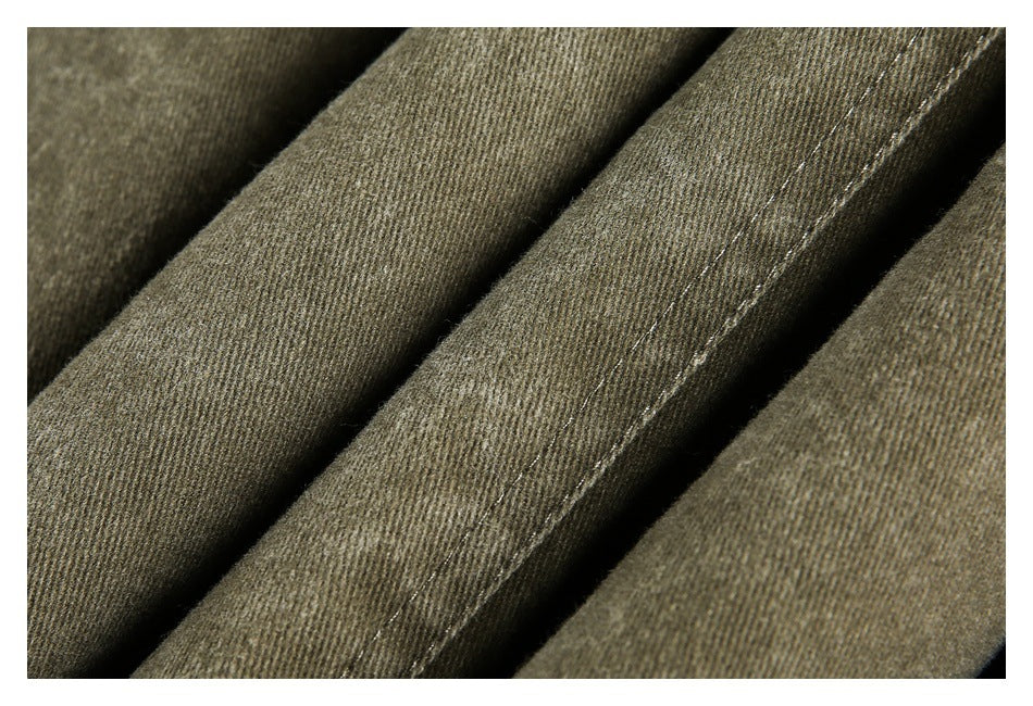 Extreme close-up of olive-brown jacket fabric folds with visible diagonal weave and stitching.