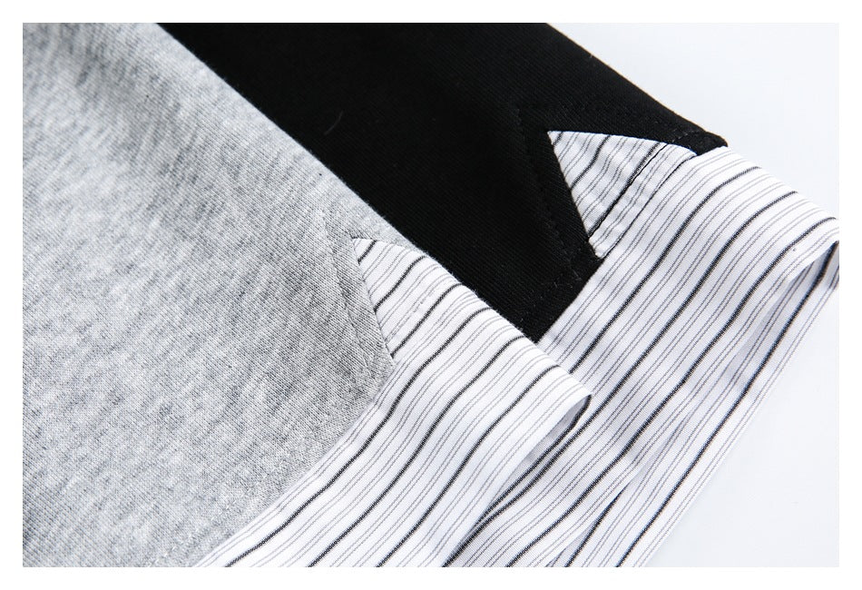Close-up of a striped white collar and cuff against gray and black fabric.