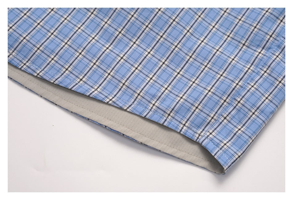 Close-up of the blue plaid garment hem with a light gray lining visible inside.