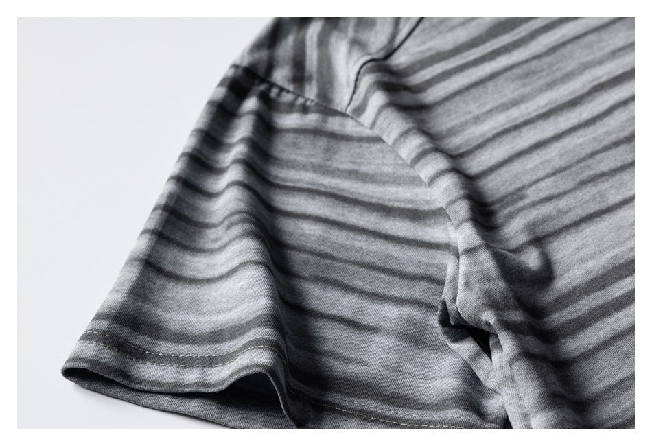 Close-up of a gray-and-charcoal striped garment showing a sleeve edge and stitched hem.
