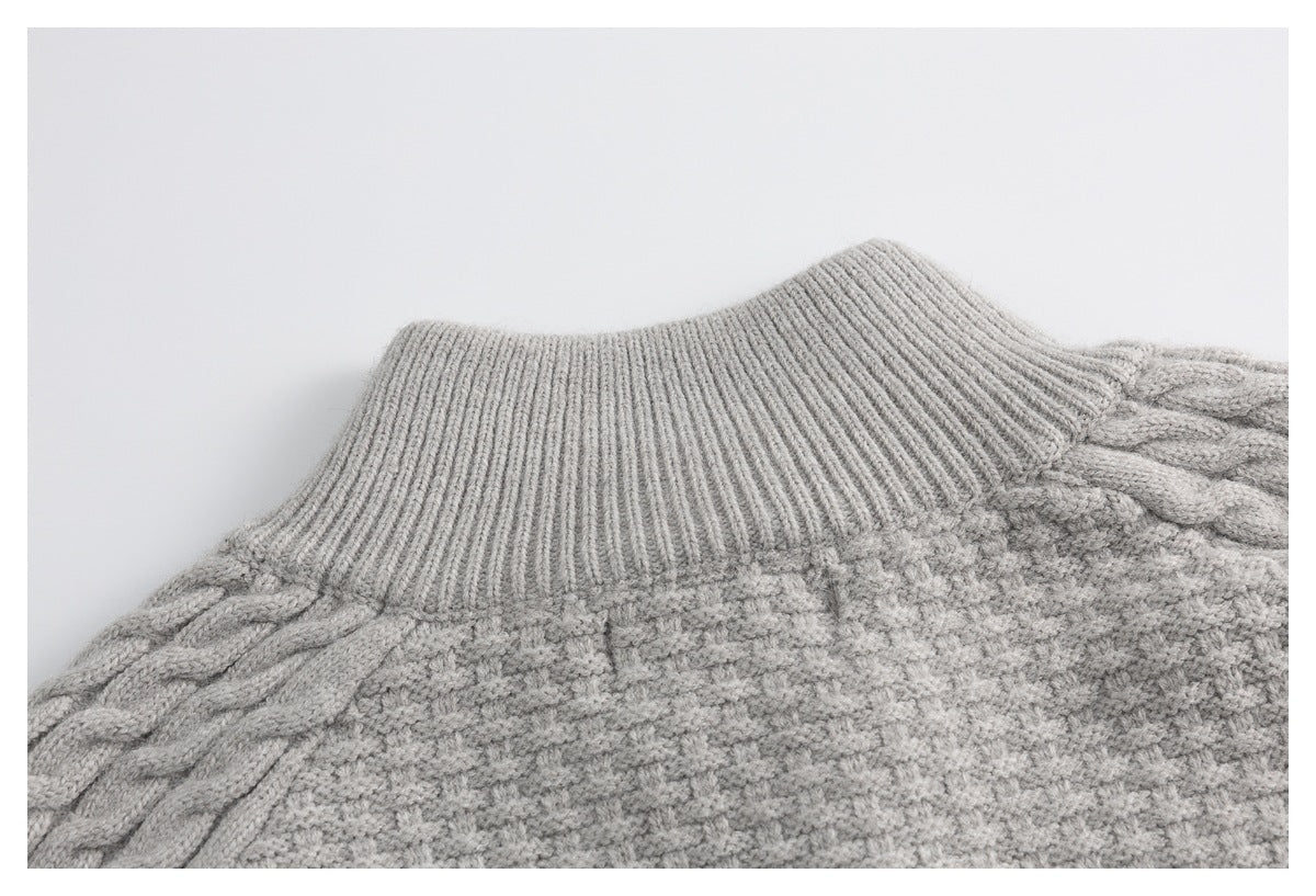 Close-up of a light gray sweater's ribbed high neckline and cable-knit shoulder.