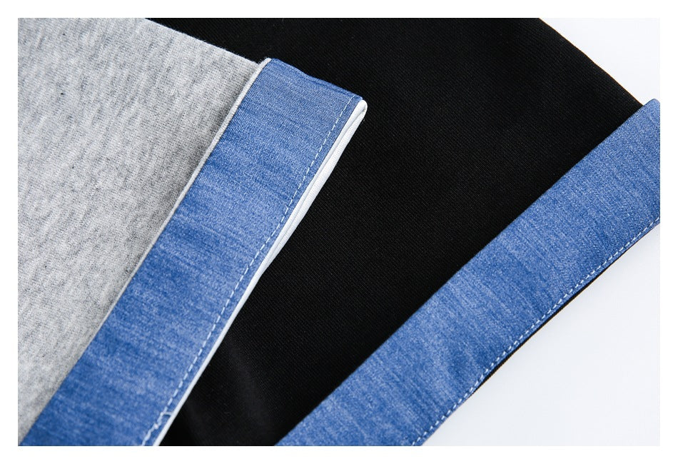 Close-up of blue denim-style trim with white piping and stitching against gray and black jacket fabric.