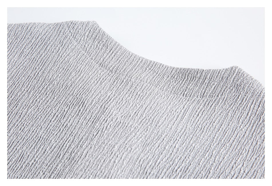 Close-up of light gray ribbed-texture fabric with a curved garment edge.