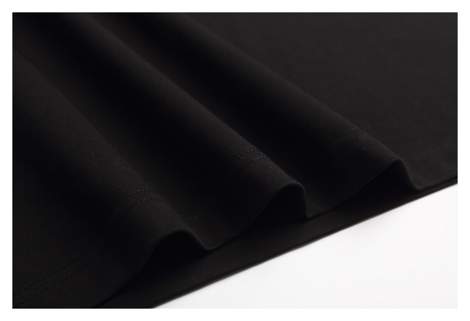 Close-up of the black T-shirt fabric folds and stitched hem.