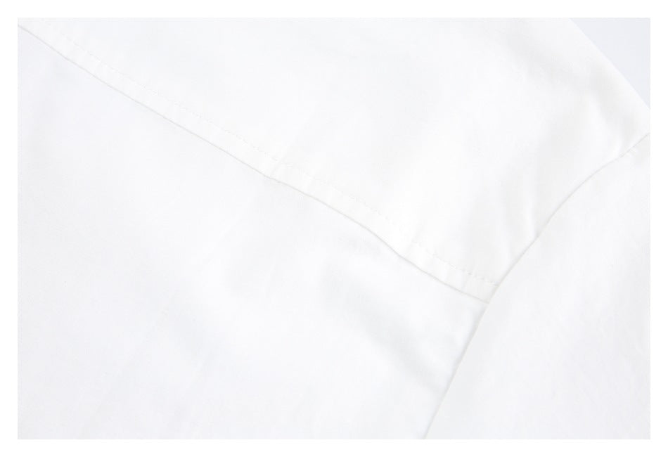 Close-up of a curved seam crossing a panel of white garment fabric.