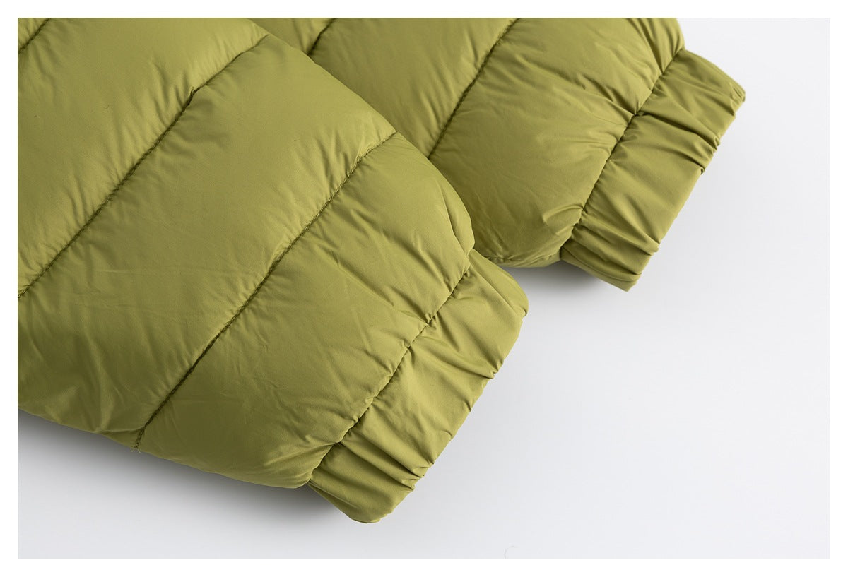 Close-up of an olive-green quilted padded garment with broad stitched sections and a gathered edge.