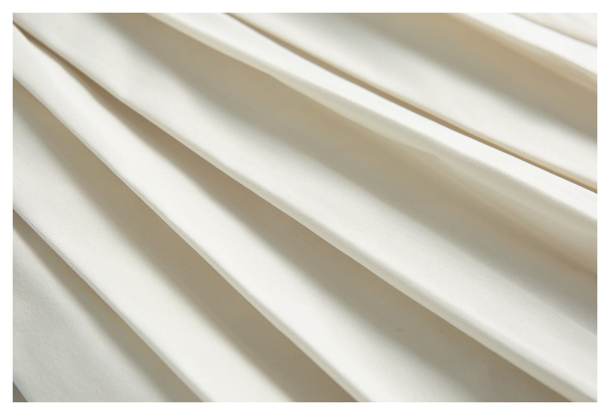 Close-up of broad, overlapping folds in the cream garment.
