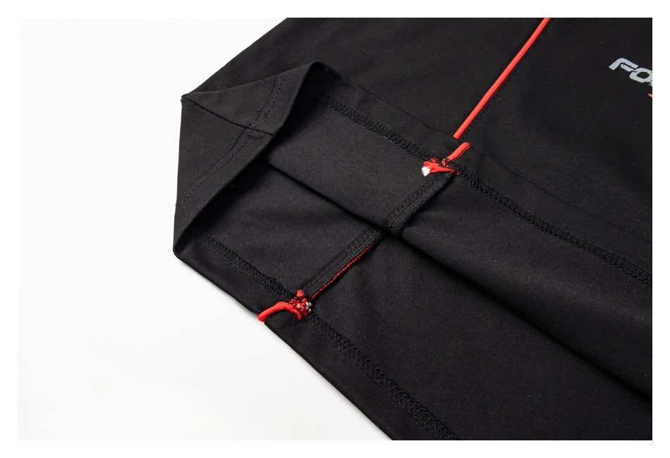 Close-up of the black shirt's turned sleeve edge and stitched seams with red thread accents.