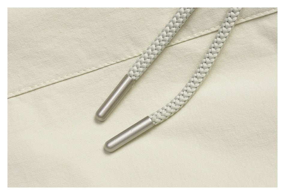 Close-up of the braided off-white drawstring with metallic end caps.