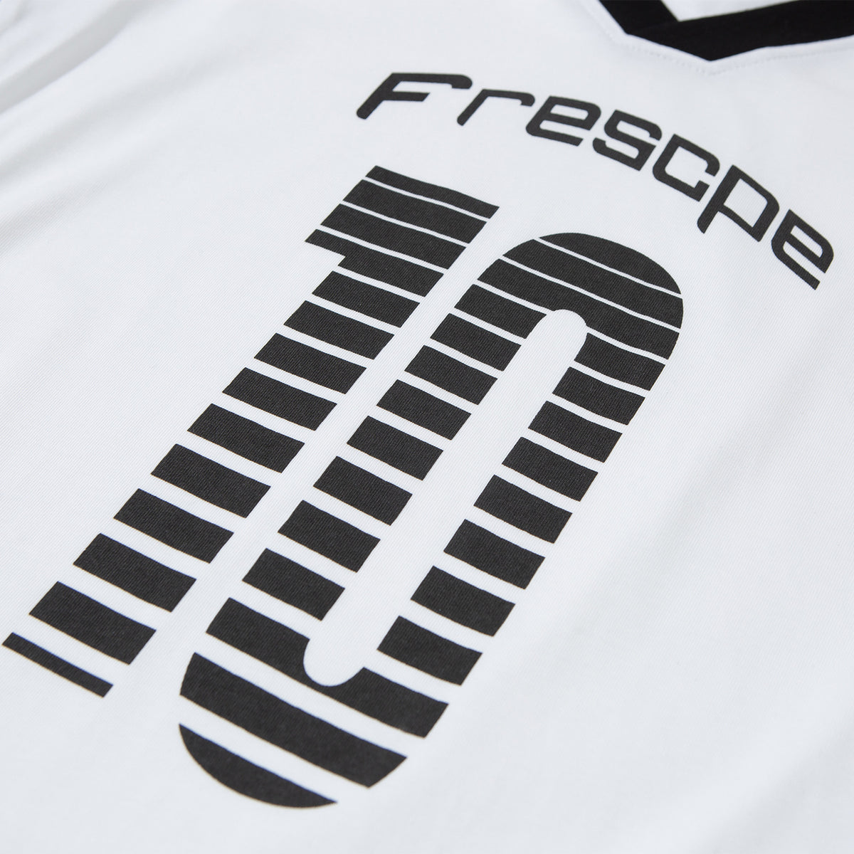 Close-up of black lettering and a large striped graphic printed on a white T-shirt.