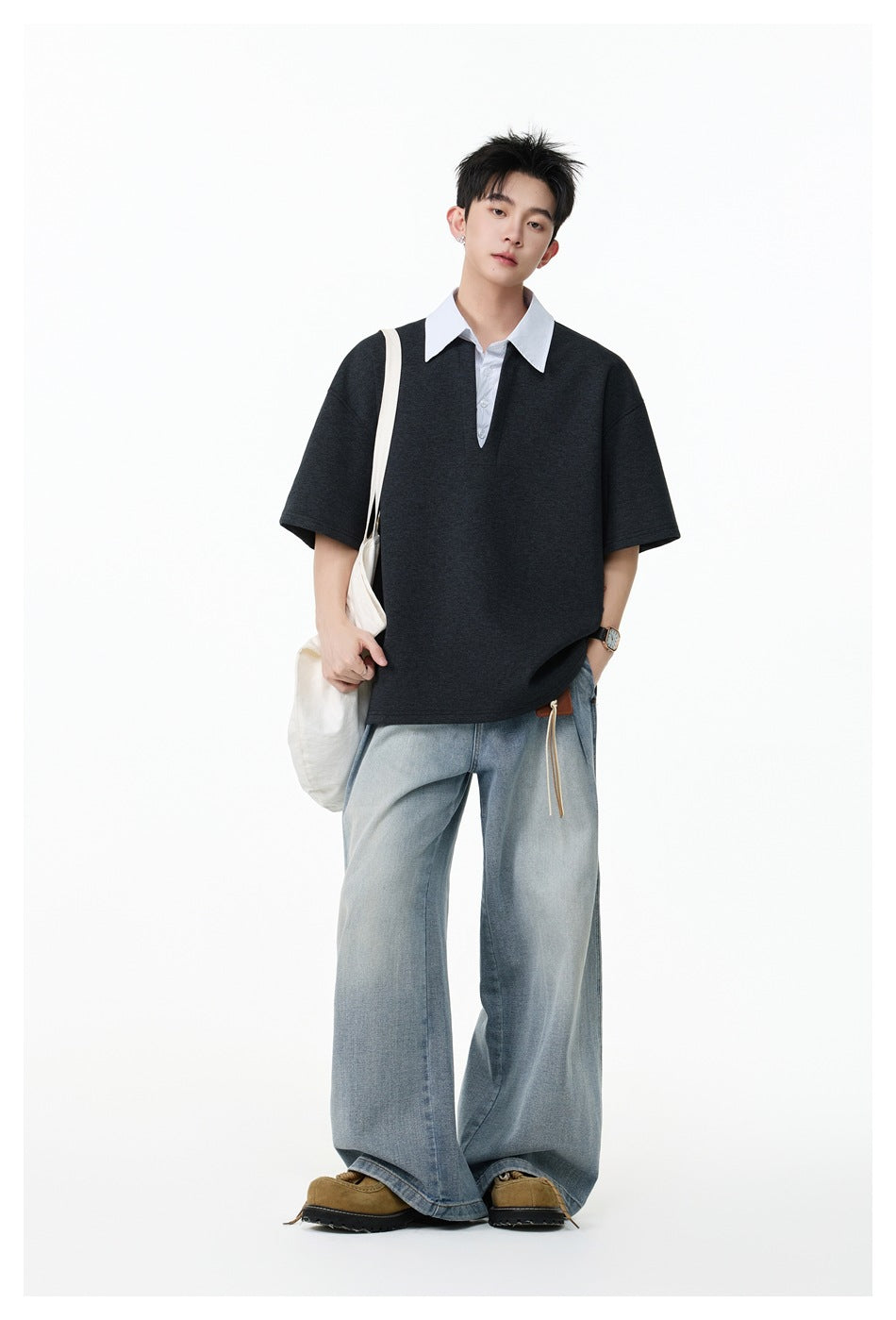 Model wearing a charcoal oversized short-sleeve shirt with a white pointed collar and loose light-wash jeans.