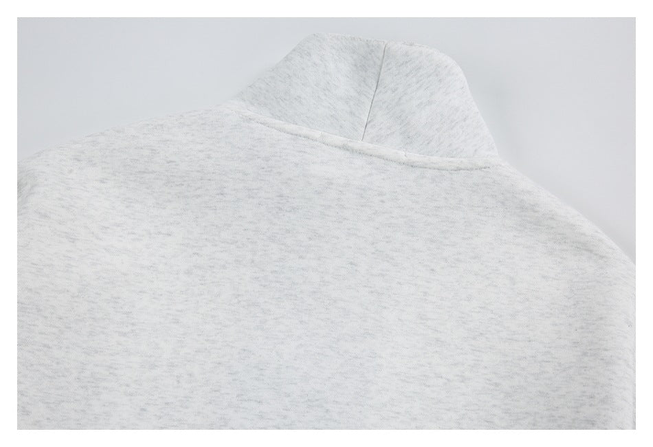 Close-up of the plain back neckline and shoulder seams of a light gray heather sweatshirt.