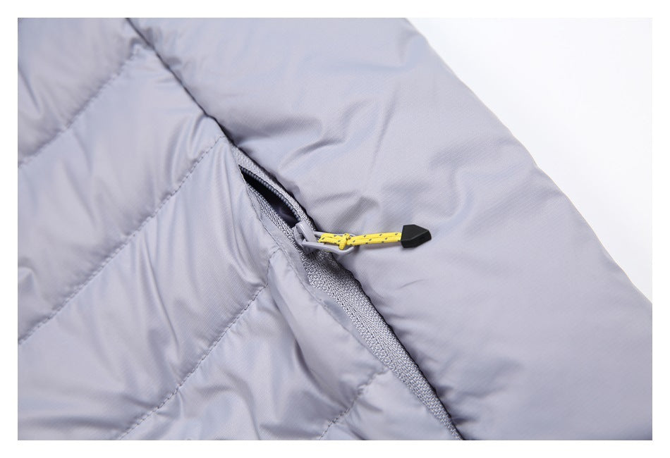 Close-up of a light gray padded jacket zipper with a yellow pull cord and black end piece.
