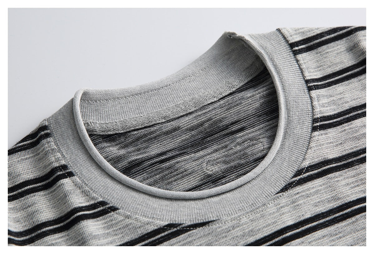 Close-up of the gray ribbed crew neck and black horizontal stripes on a shirt, framed by a thin border.