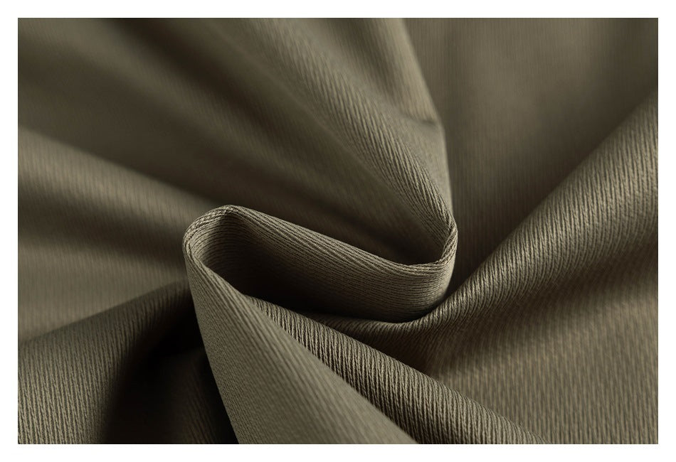 Close-up of olive fabric folded to show its surface texture and drape.