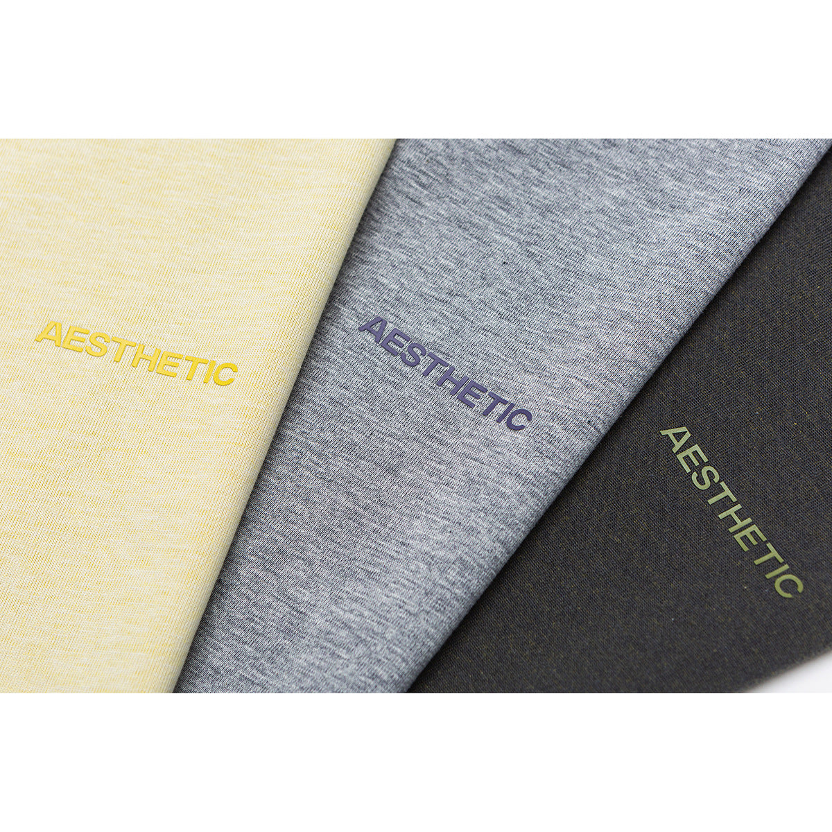 Close-up of yellow, gray melange, and charcoal fabric panels with matching AESTHETIC lettering.