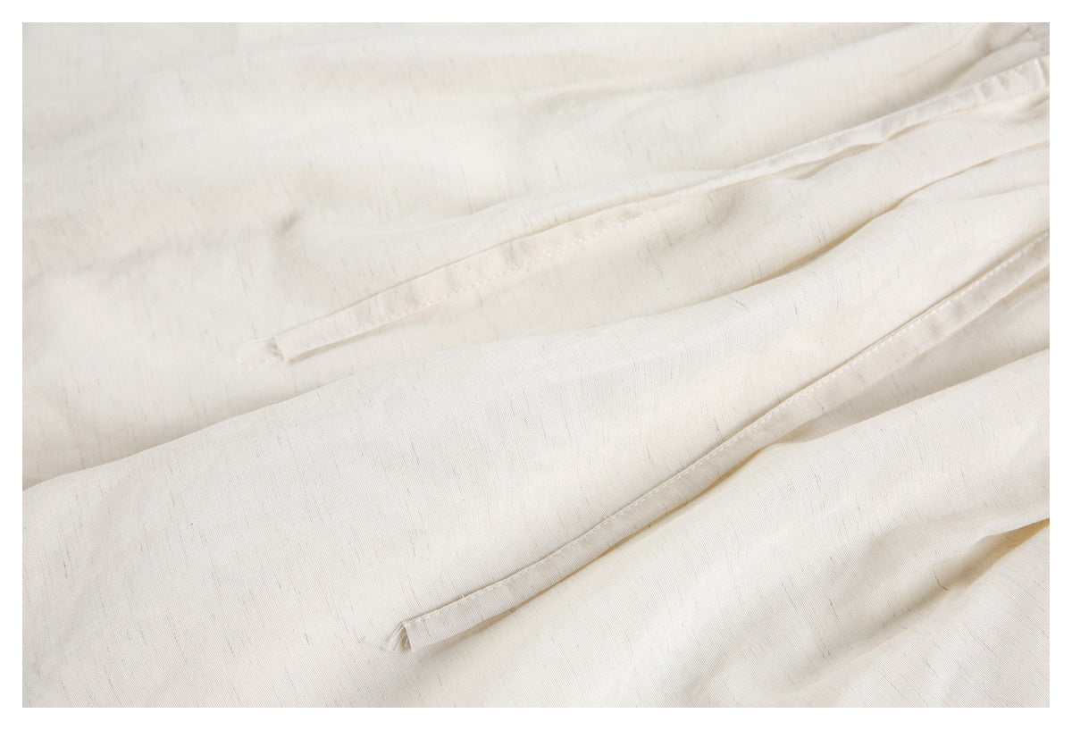 Close-up of the ivory shorts' drawstrings and lightly textured fabric.