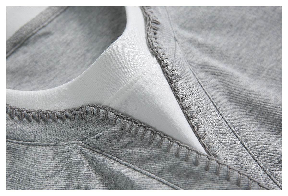 Close-up of a gray garment neckline with white inner trim and prominent seam stitching.