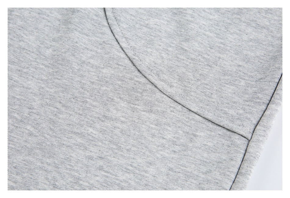 Close-up of light gray heather sweatpants showing a curved pocket seam and side stitching.