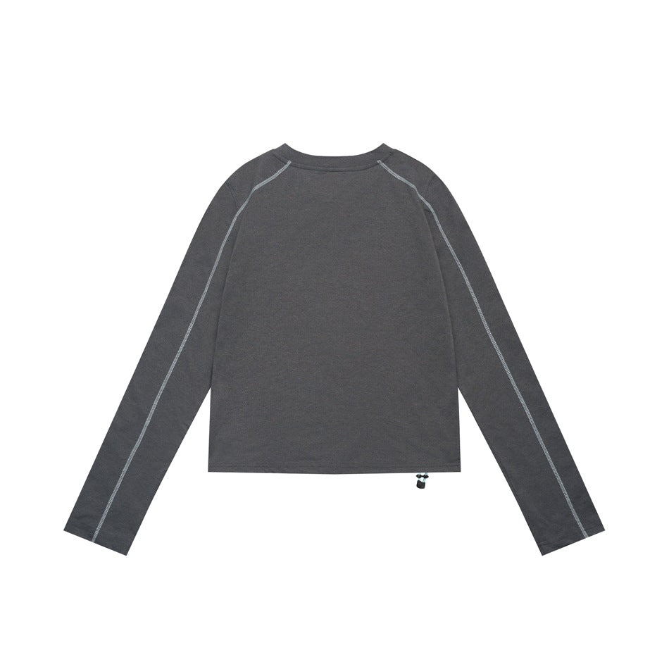 Back view of a charcoal long-sleeve top with light contrast raglan seams and a small hem drawcord toggle.