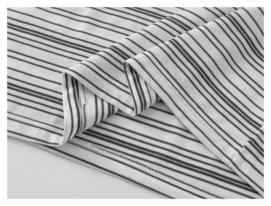Close-up of a white shirt with thin black stripes, showing folded fabric and overlock stitching.