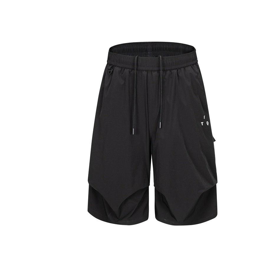 Black knee-length drawstring shorts with side flap pocket and layered pleated hem, front view