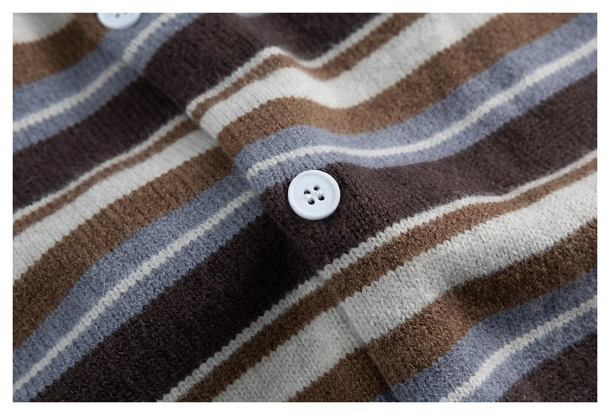 Close-up of a white button on the cardigan's multicolored striped knit fabric.