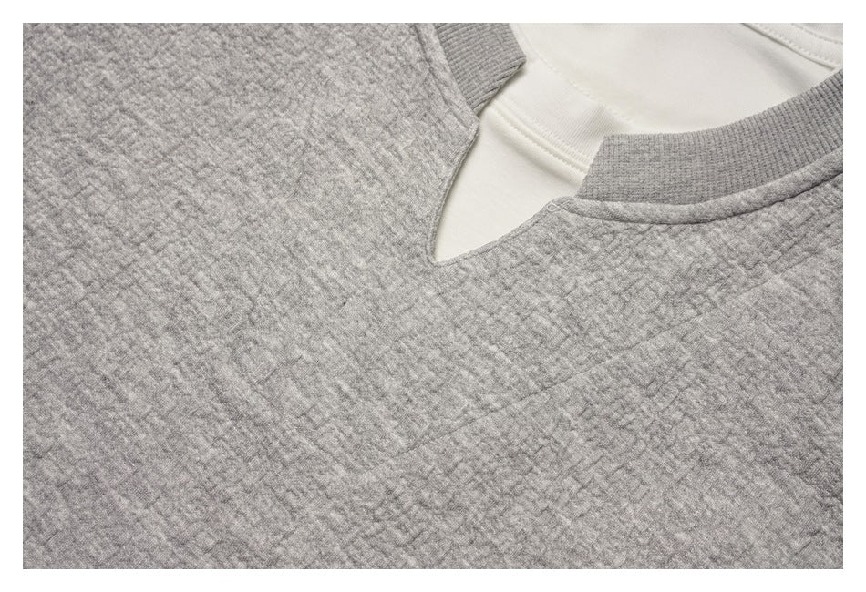Close-up of the gray textured sweatshirt neckline and white inner layer.