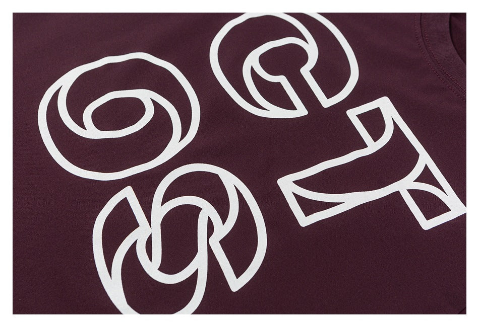 Close-up of large white outlined graphics on the dark burgundy T-shirt.