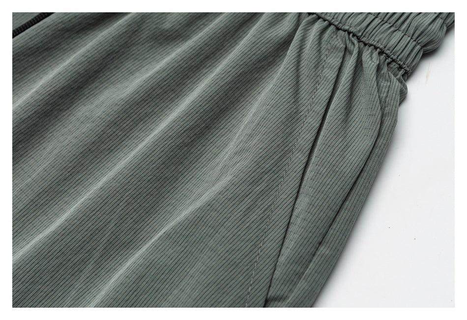 Close-up of a blue-gray finely striped garment showing a side seam and gathered elastic edge.
