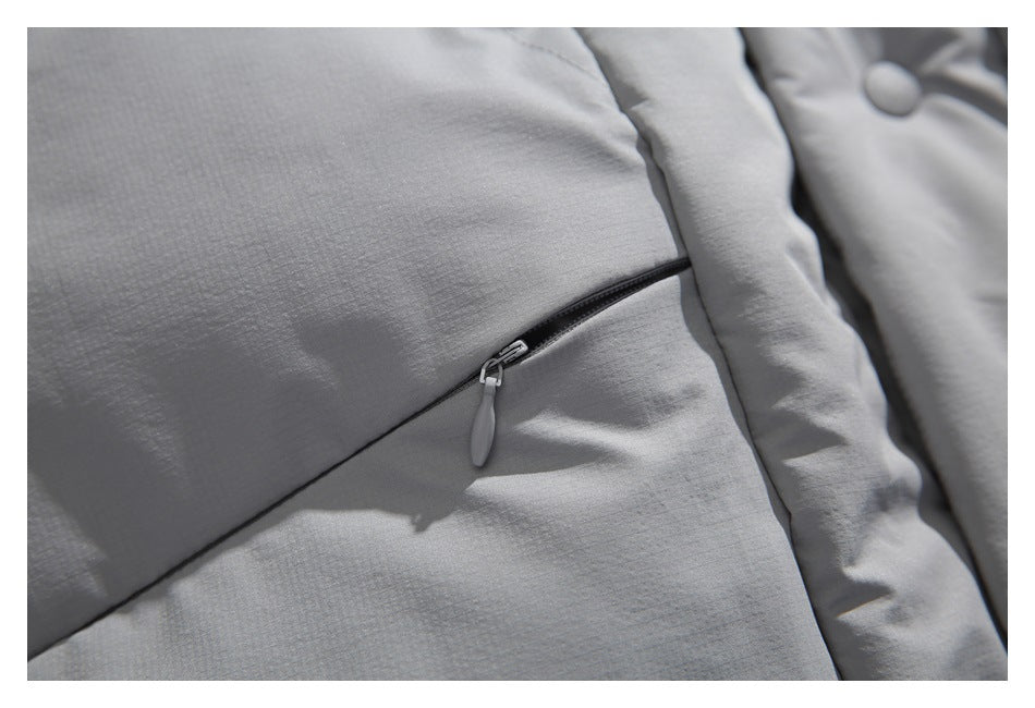 Close-up of a diagonal zip pocket on a light gray padded jacket.