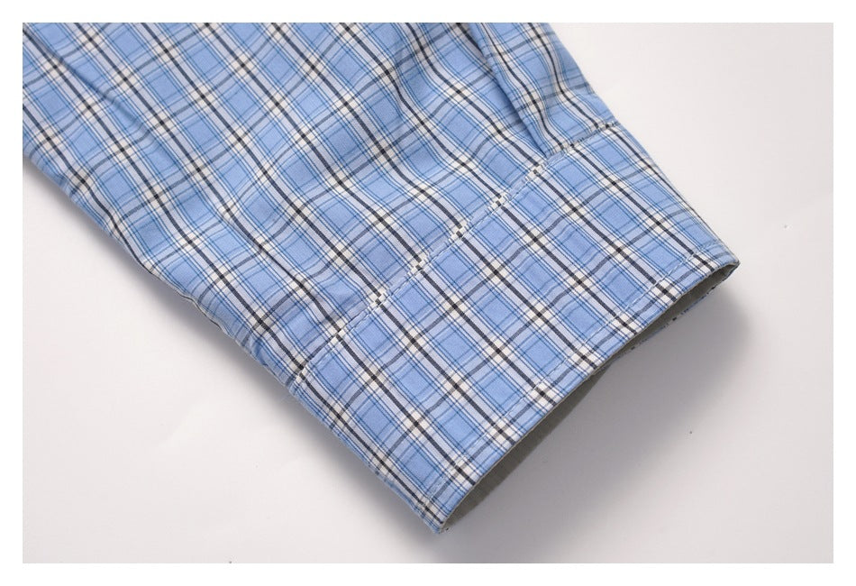 Close-up of a blue plaid sleeve ending in a wide cuff with visible stitching.