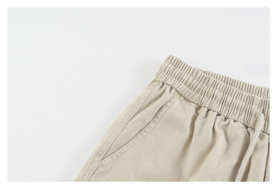 Close-up of the angled side pocket and gathered waistband on beige shorts.