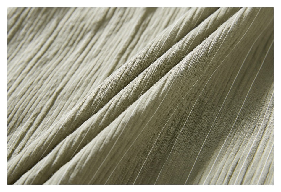 Macro view of the shirt's muted olive-gray striped fabric and folded construction.