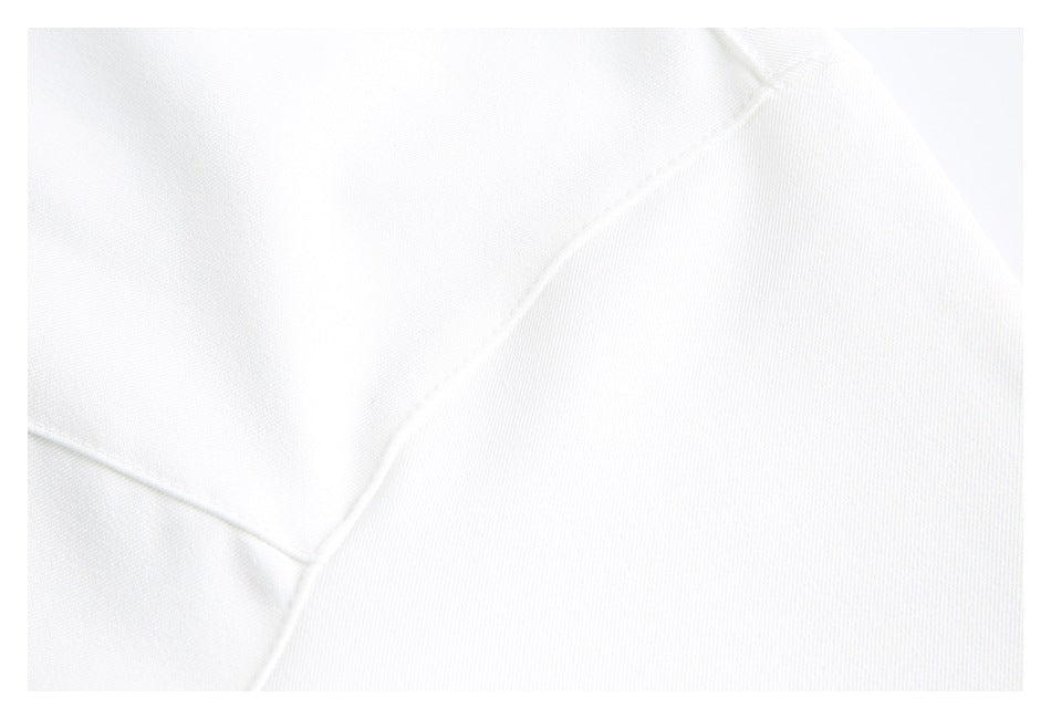 Close-up of white garment fabric showing curved seams and stitching.