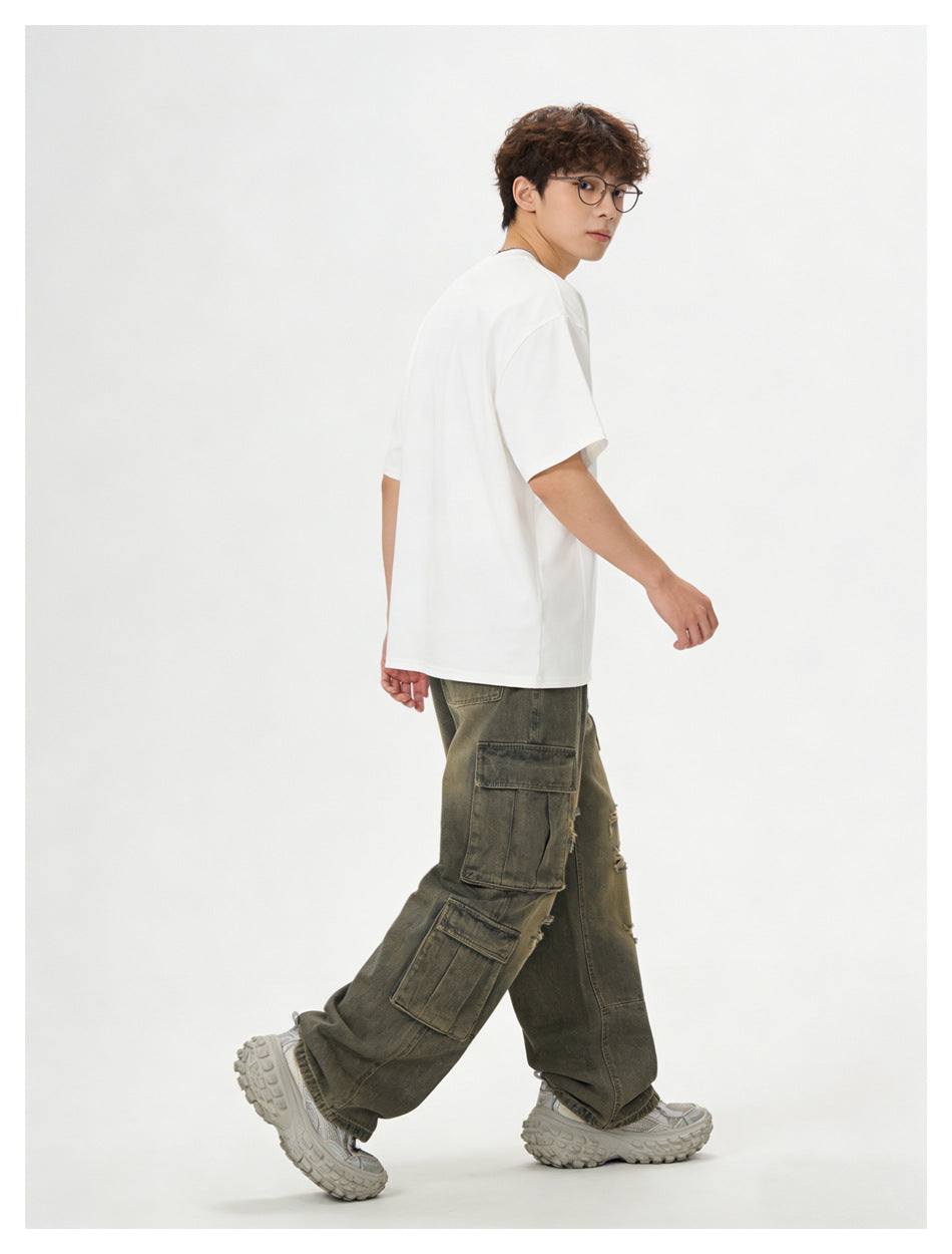 Rear three-quarter view of a model in a plain white T-shirt and olive-gray cargo pants with large pockets.