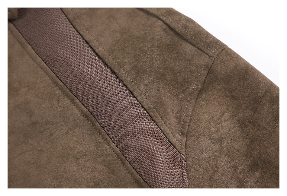 Close-up of a brown jacket's shoulder seam and wide dark textured trim.