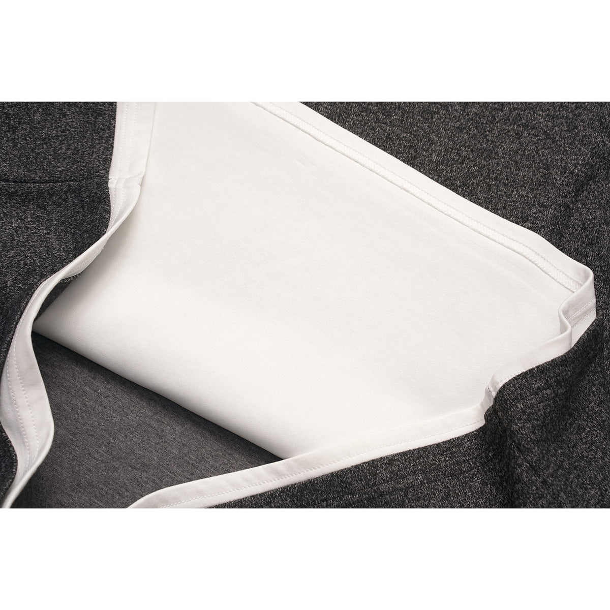 Close-up of the white inner layer and seams inside a charcoal marled top.