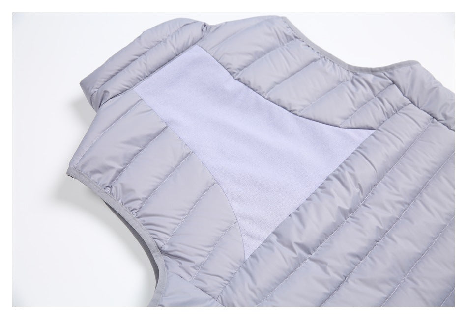 Cropped back view of a light gray sleeveless quilted vest with a wide contrasting knit panel.