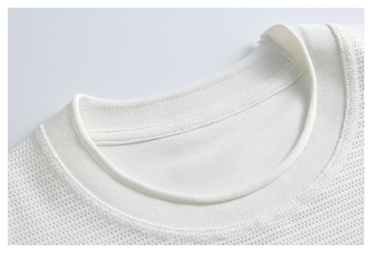 Close-up of a white T-shirt’s ribbed crew neckline and textured knit fabric.