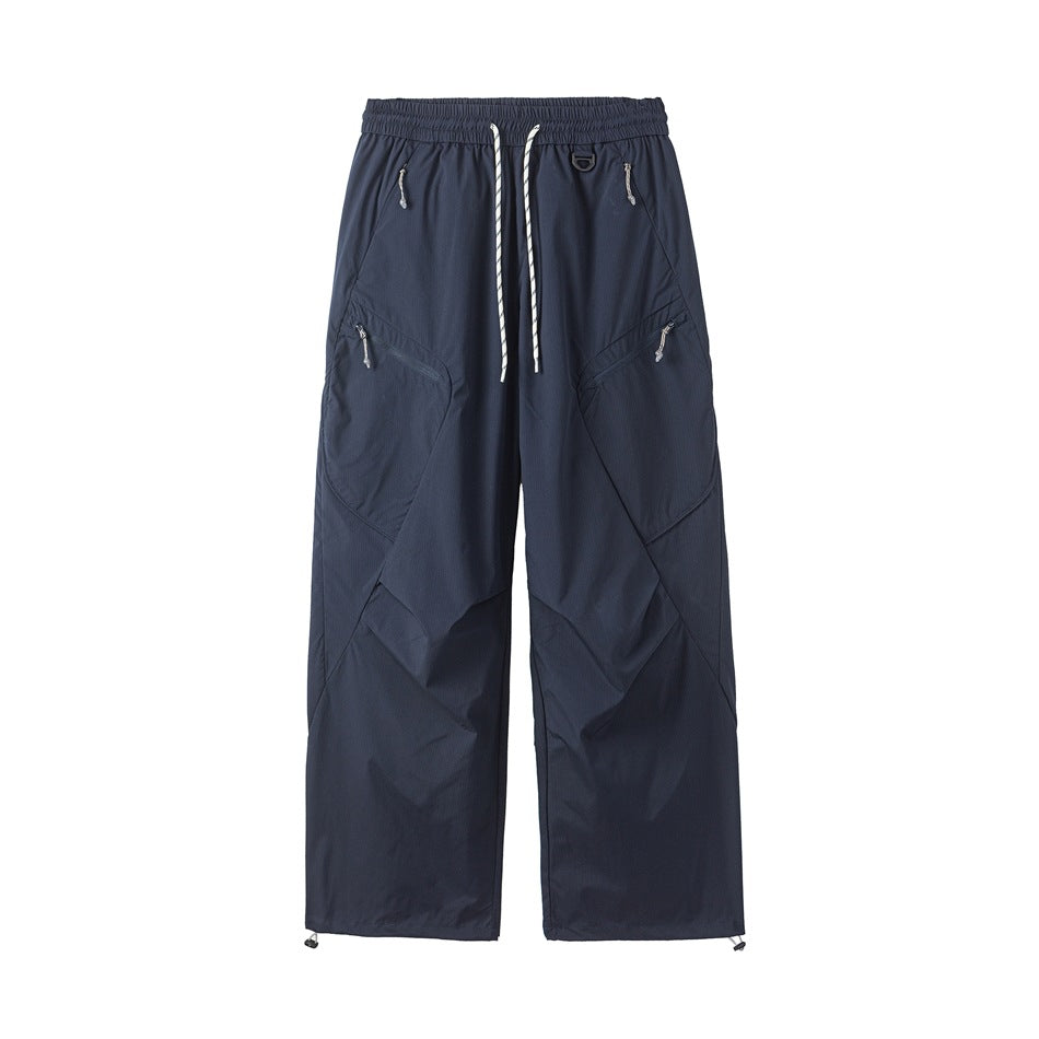 Navy blue wide-leg drawstring pants with diagonal zip pockets and toggle hems, front flat view